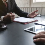 Profesionales comentando documentación durante una consulta laboral